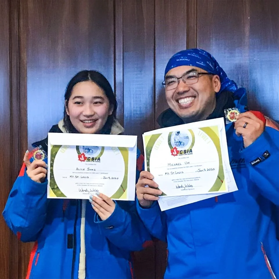 two people holding up with CSIA level one ski certification