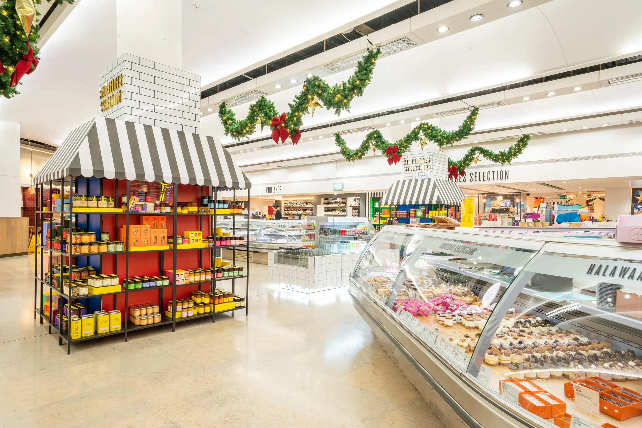 Selfridges x Disney Christmas installation — wide shot of the food hall counter with festive decorations, London commercial environment and brand space photography for retail marketing