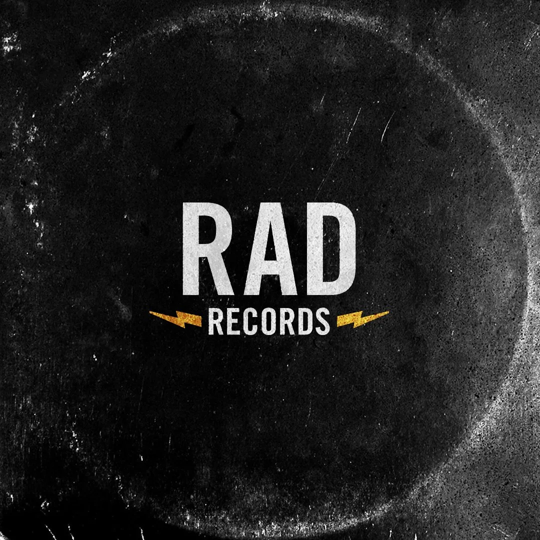 Sign for RAD Records mounted on a beige brick wall