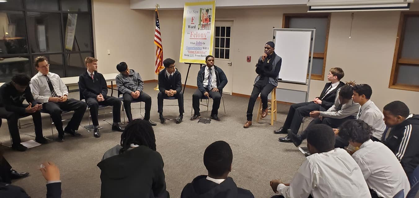 Mentoring Group of young males seated in a circle having a discussion in a room with Bhagwan Ra Afrika.