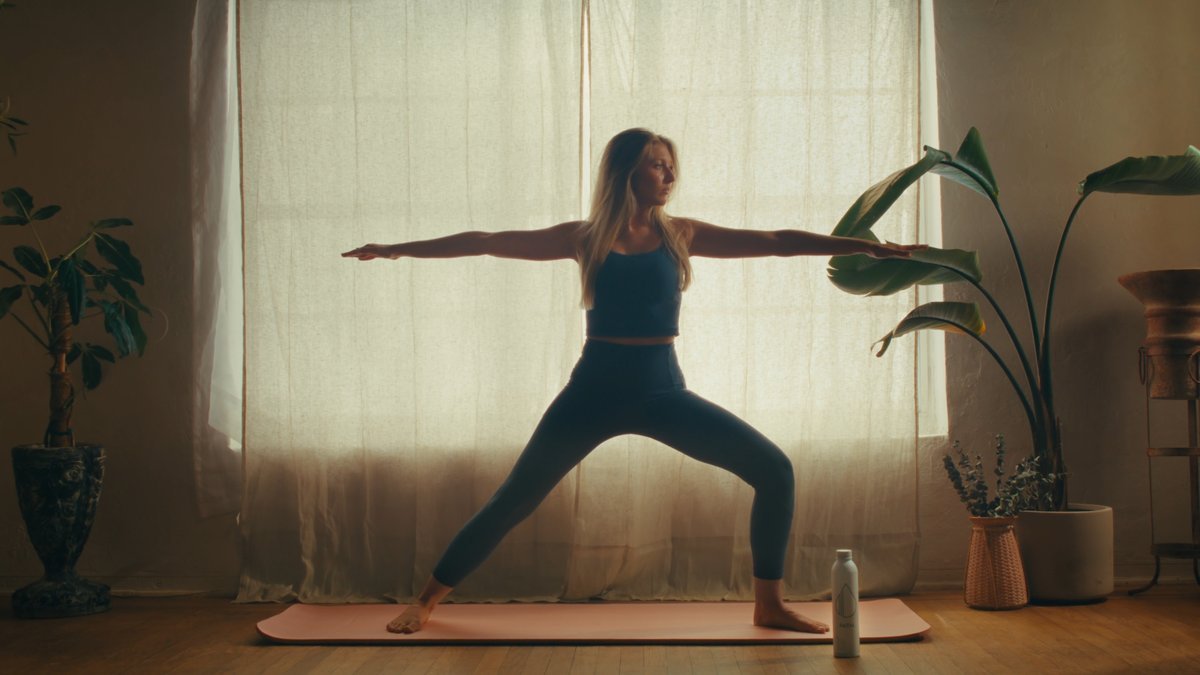 SHOT 11
Maggie performs light yoga in the living room; Milo sniffs around.