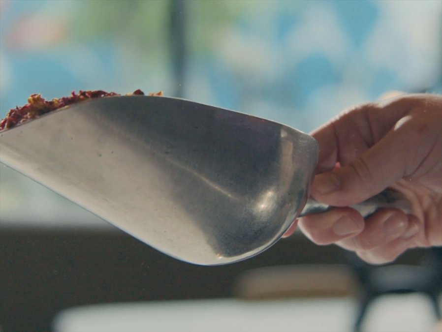 SHOT 9
Close-up: She scoops Pupford kibble into a small bowl.