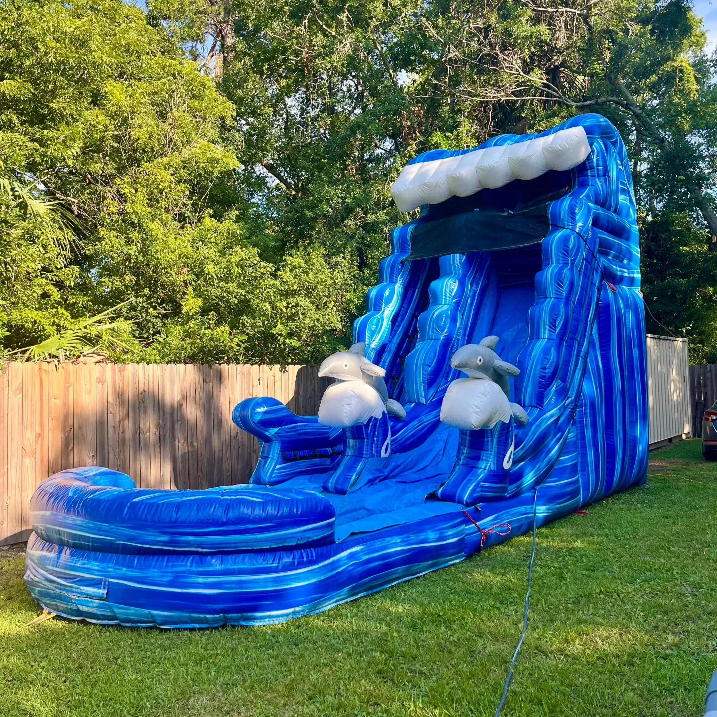 Big Flipper 18-ft inflatable water slide rental in Brunswick GA set up for a backyard summer party.