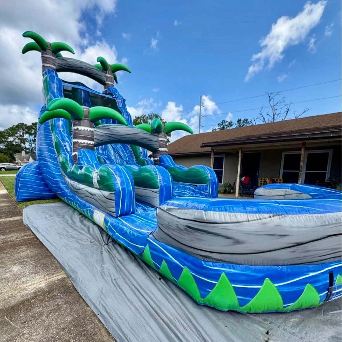 Side angle of the River Rush 22-foot water slide rental in Brunswick, Georgia, highlighting the steep slide height, secure climbing steps, and wide landing area.