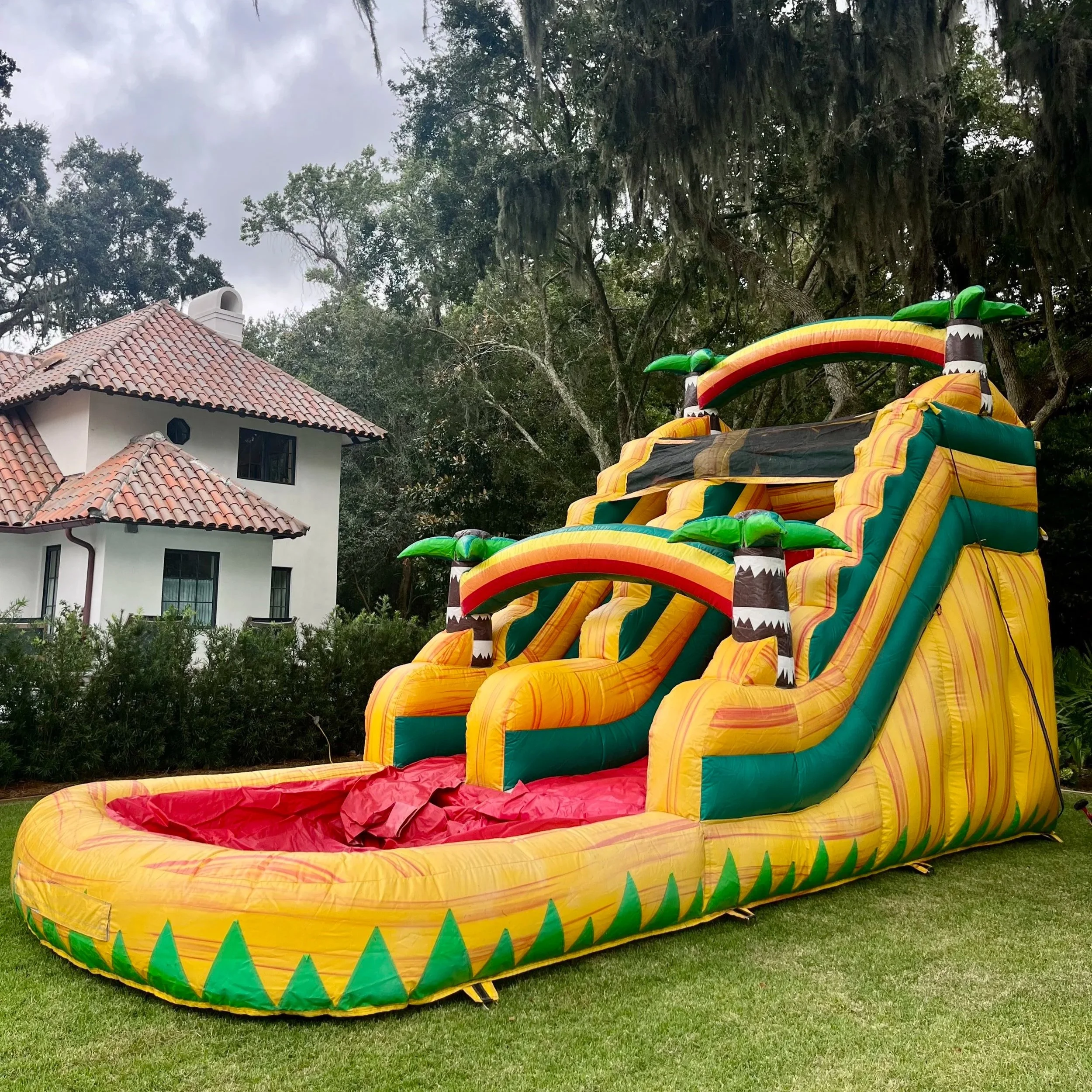 Side angle of Sunshine Falls inflatable water slide showing wide climbing steps and smooth slide lane.