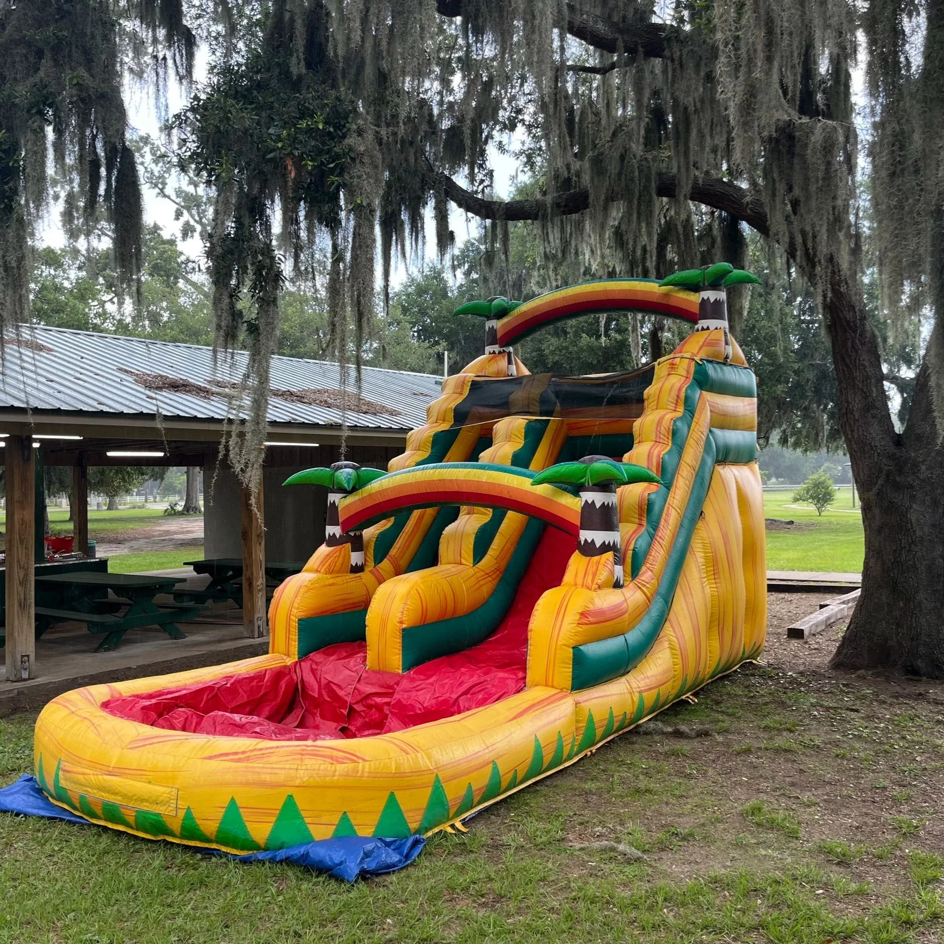 Bright tropical Sunshine Falls inflatable water slide adding bold color and fun to outdoor parties.