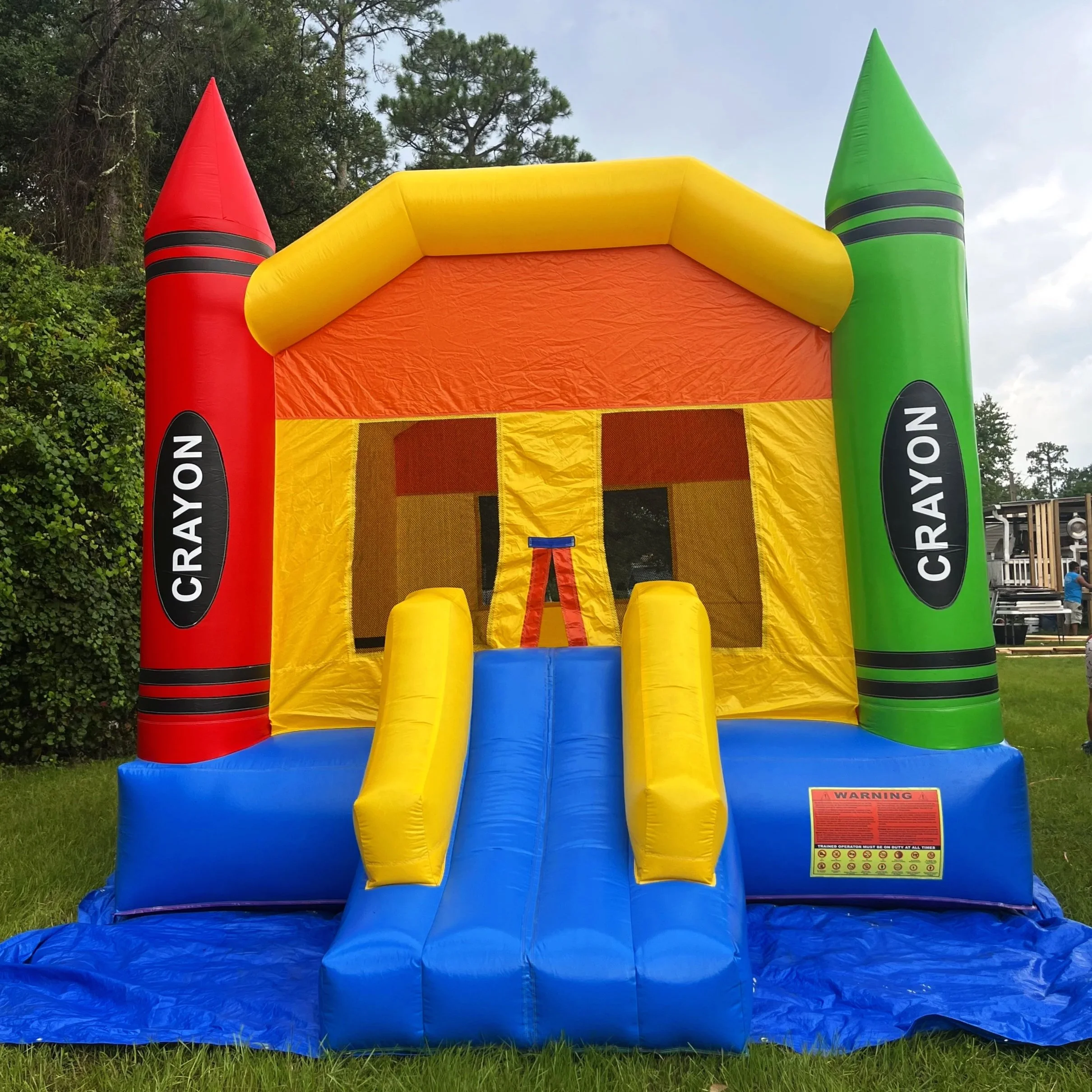 Crayon Castle inflatable bounce house with slide for kids’ parties.