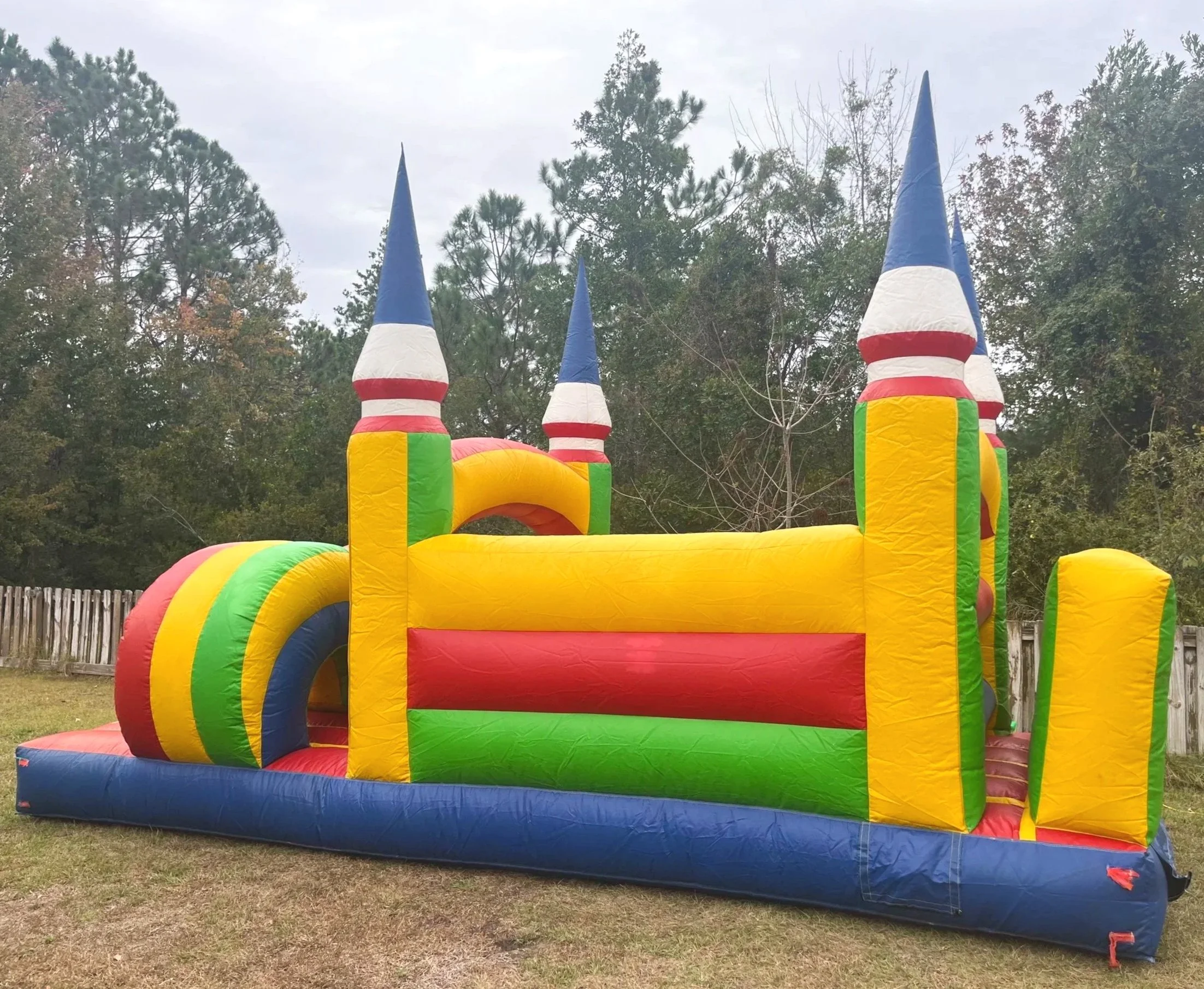 Colorful Lil Challenger inflatable obstacle course set up in a backyard for a child’s birthday party.