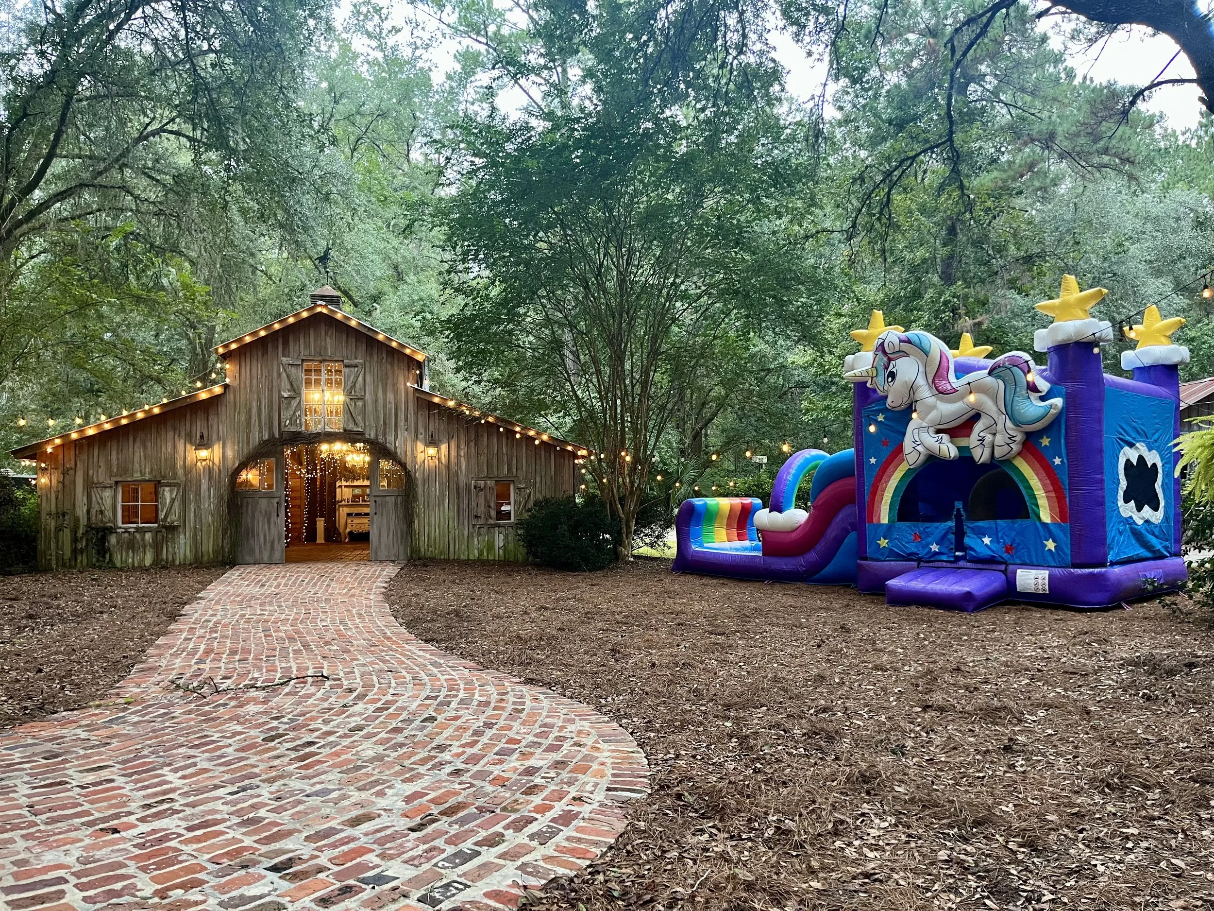 Unicorn Playland bounce house and waterslide combo rental in Brunswick GA set up for a backyard birthday party.