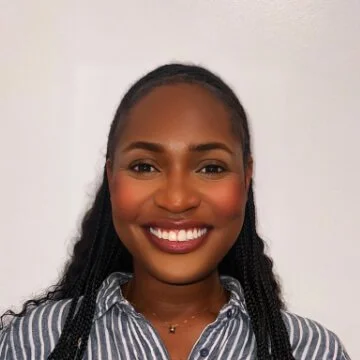 Venissa Vincent, care coordinator, with a smile, wearing a striped shirt, and standing against a plain background.