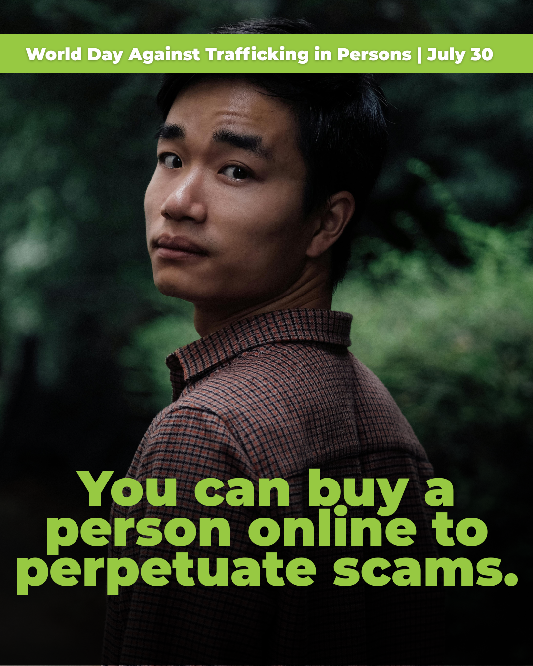 A young Asian man looking over his shoulder