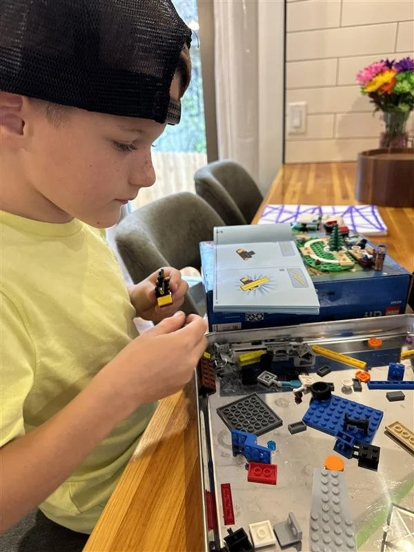 Young boy in hat builds Legos