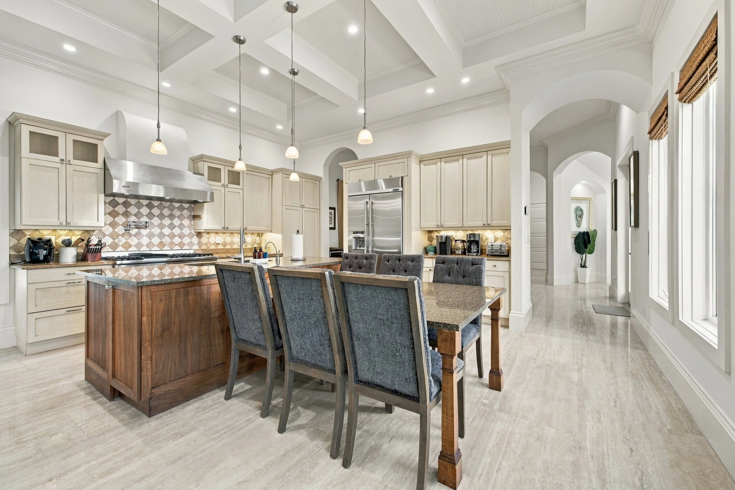 Kitchen with large island, dining table and coffered ceiling