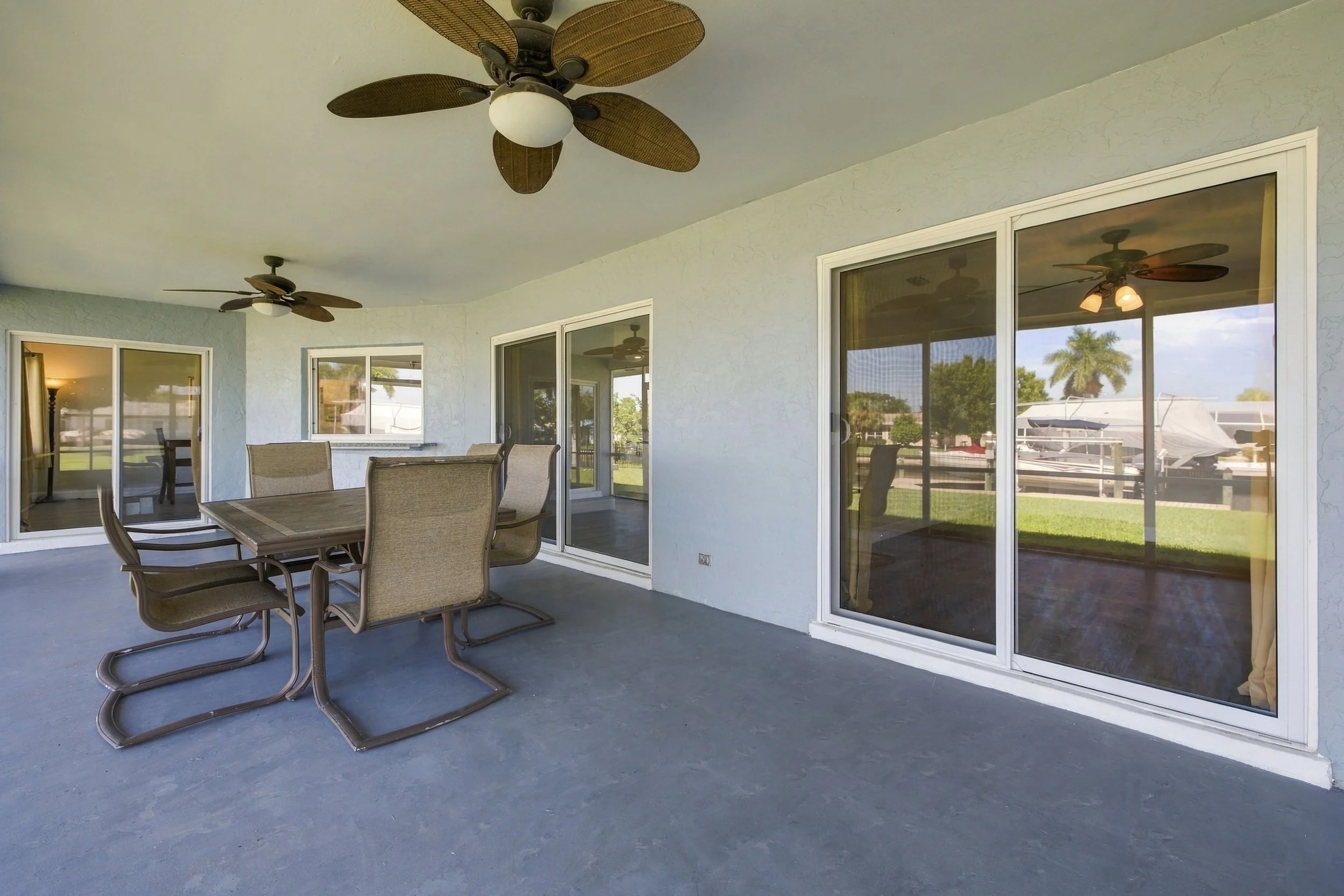 Covered lanai with ceiling fan and outdoor dining set