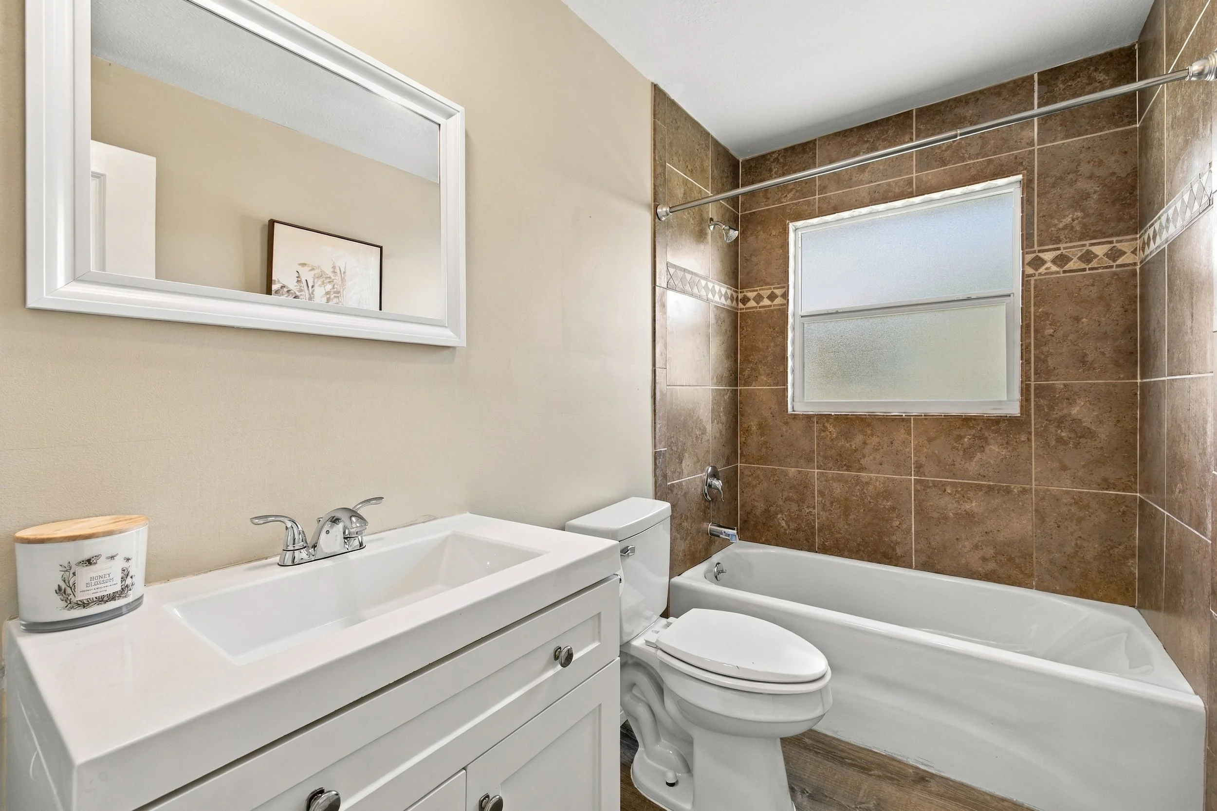 Bathroom with tub, tile surround and white vanity