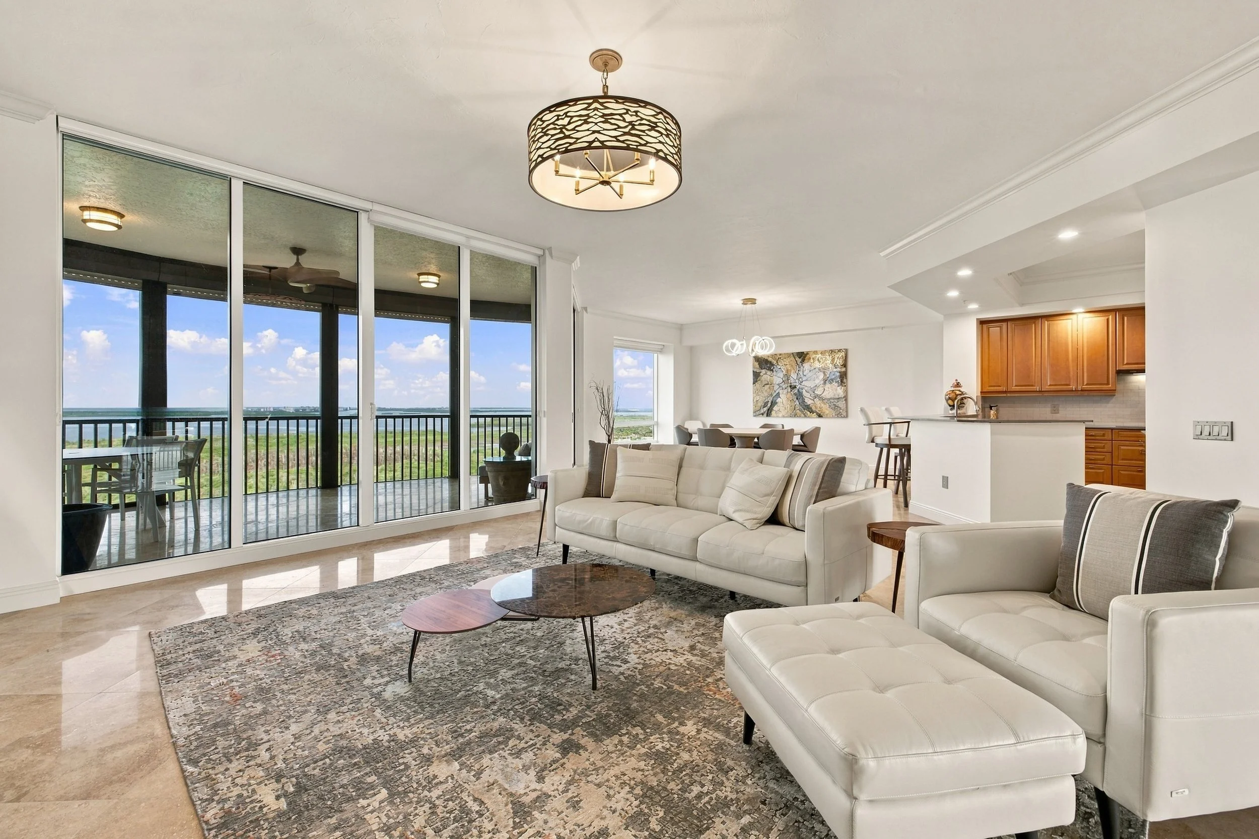Living room with floor-to-ceiling windows and neutral furniture