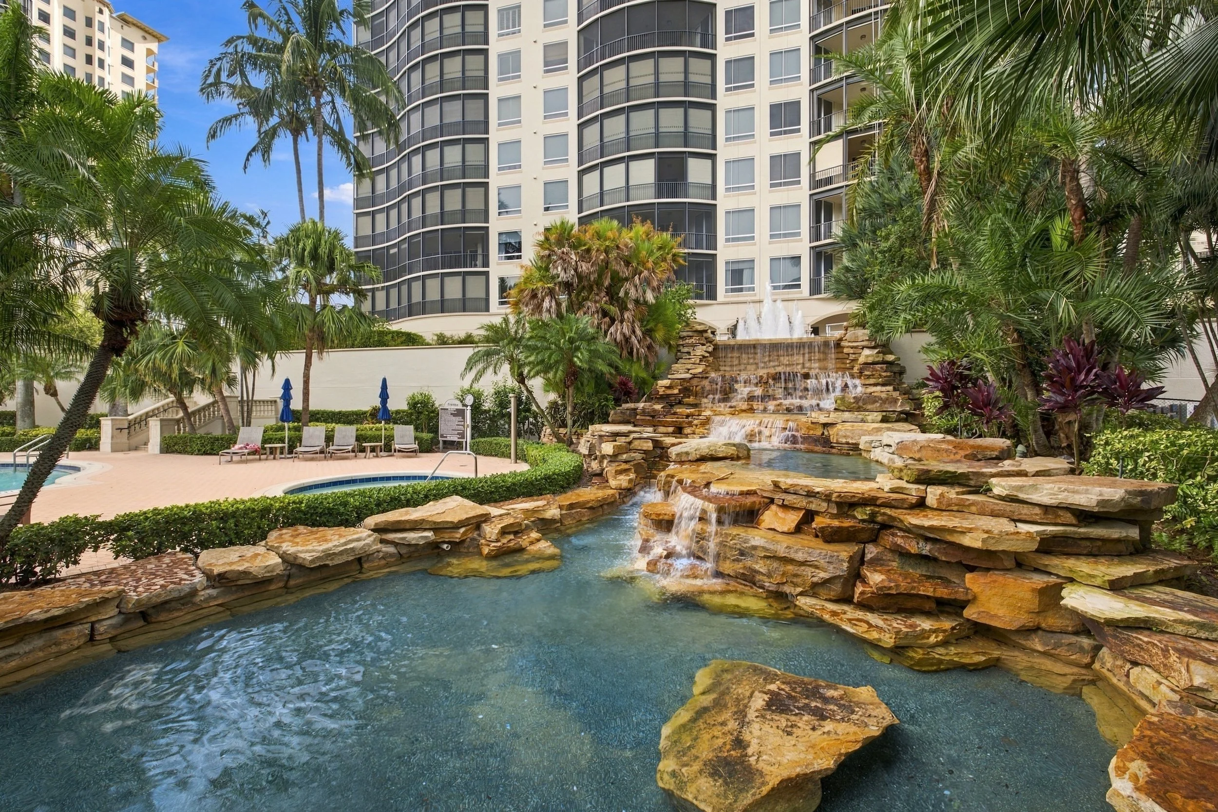Rock waterfall pool beside high-rise condos, a common amenity in Bonita Springs communities