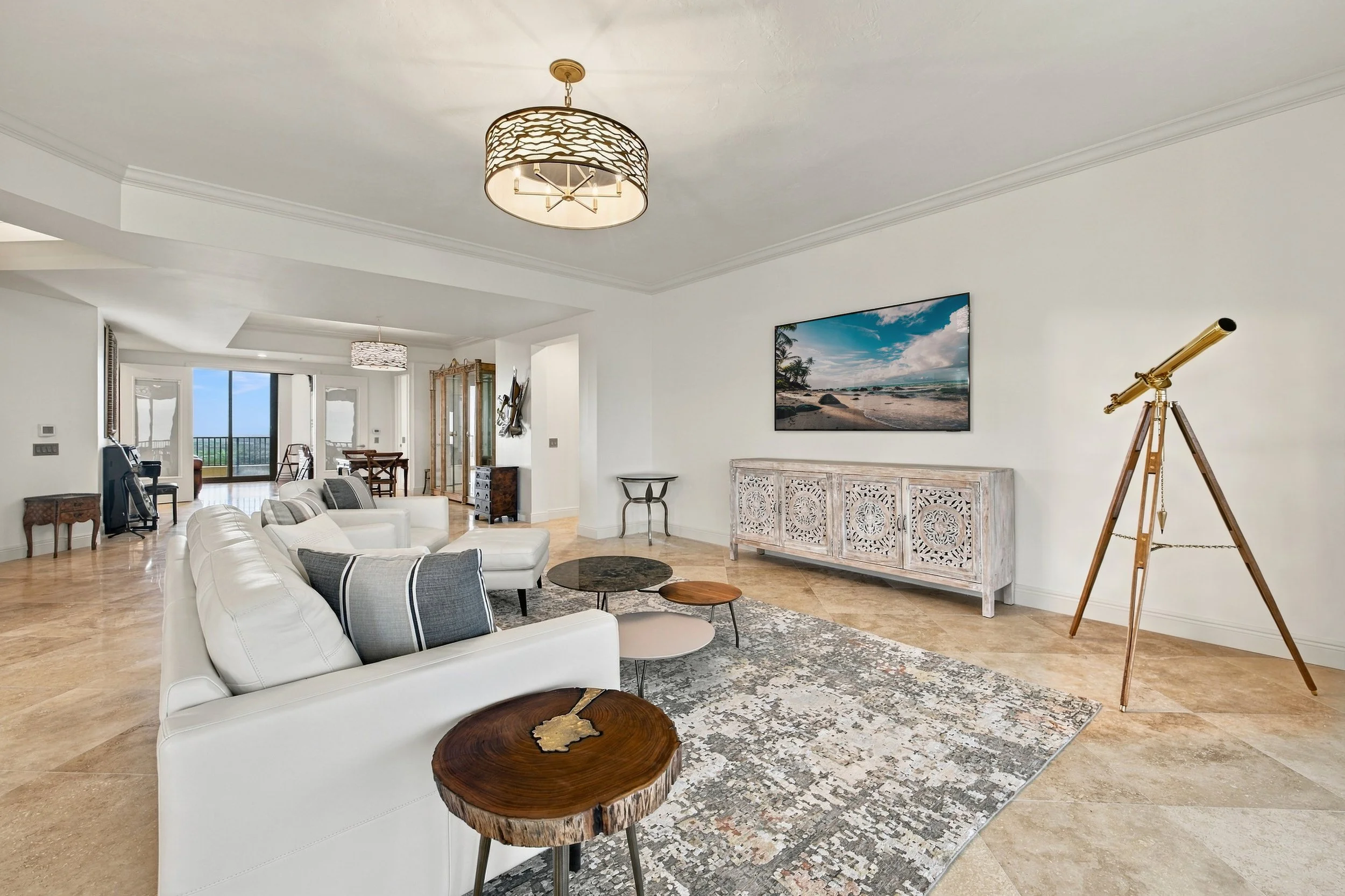 Condo living room with gray sofas, telescope and wide windows