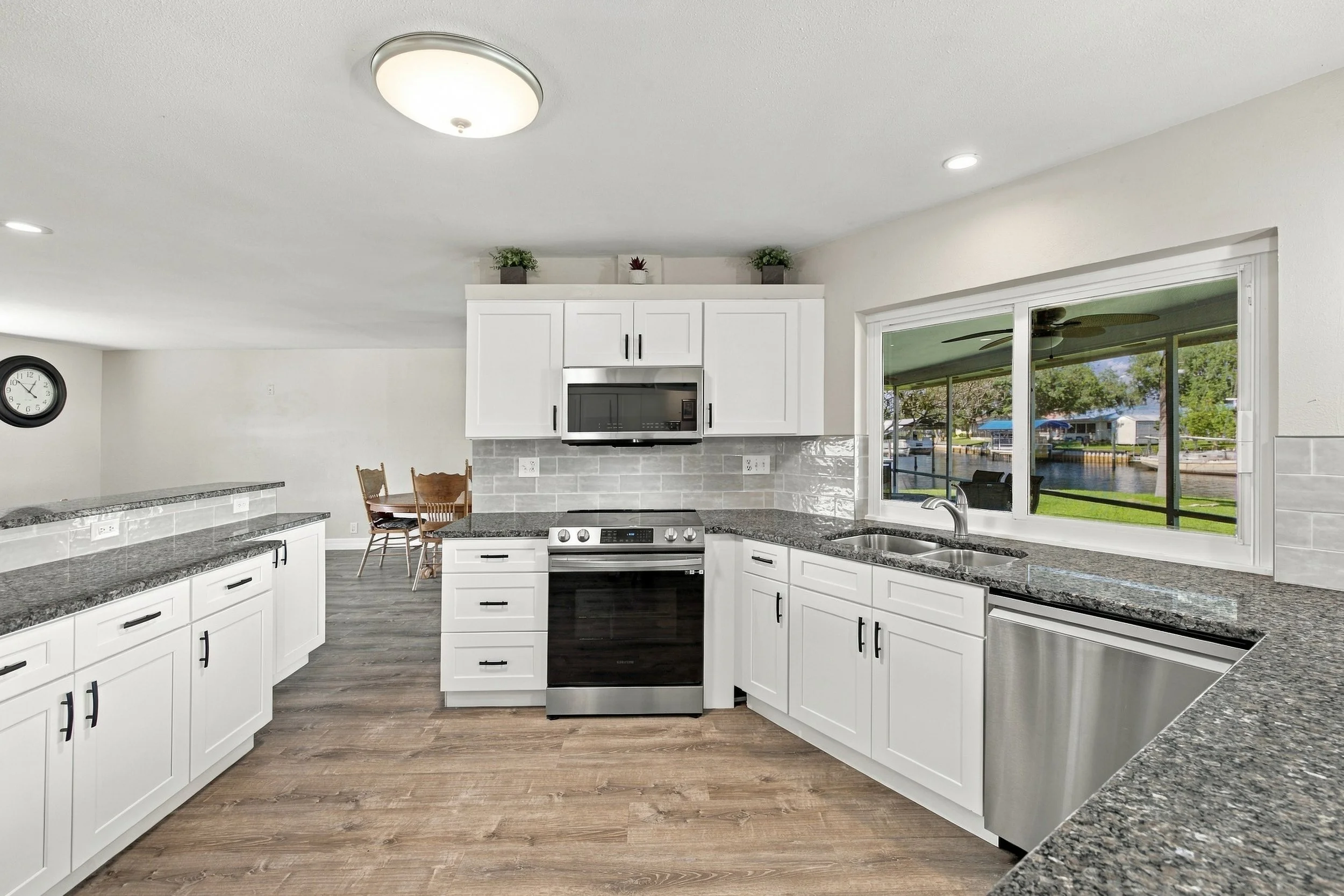 White kitchen with stainless steel appliances and granite counters