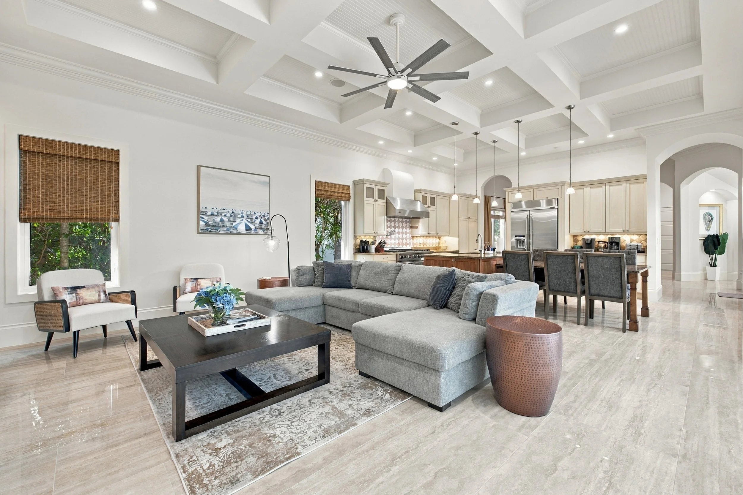 Great room with gray sectional, ceiling fan and dining area