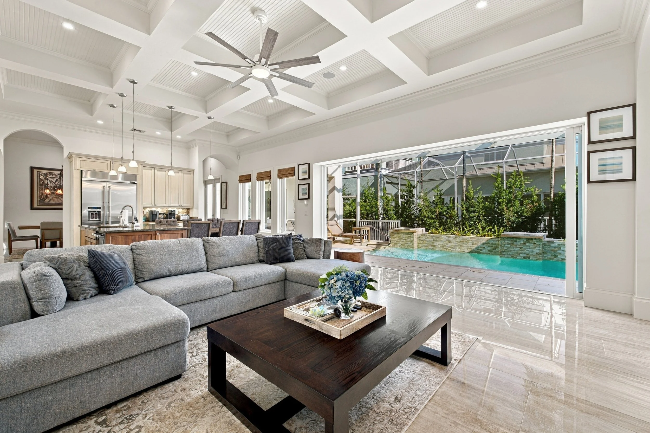Living room with sectional sofa opening to a pool lanai