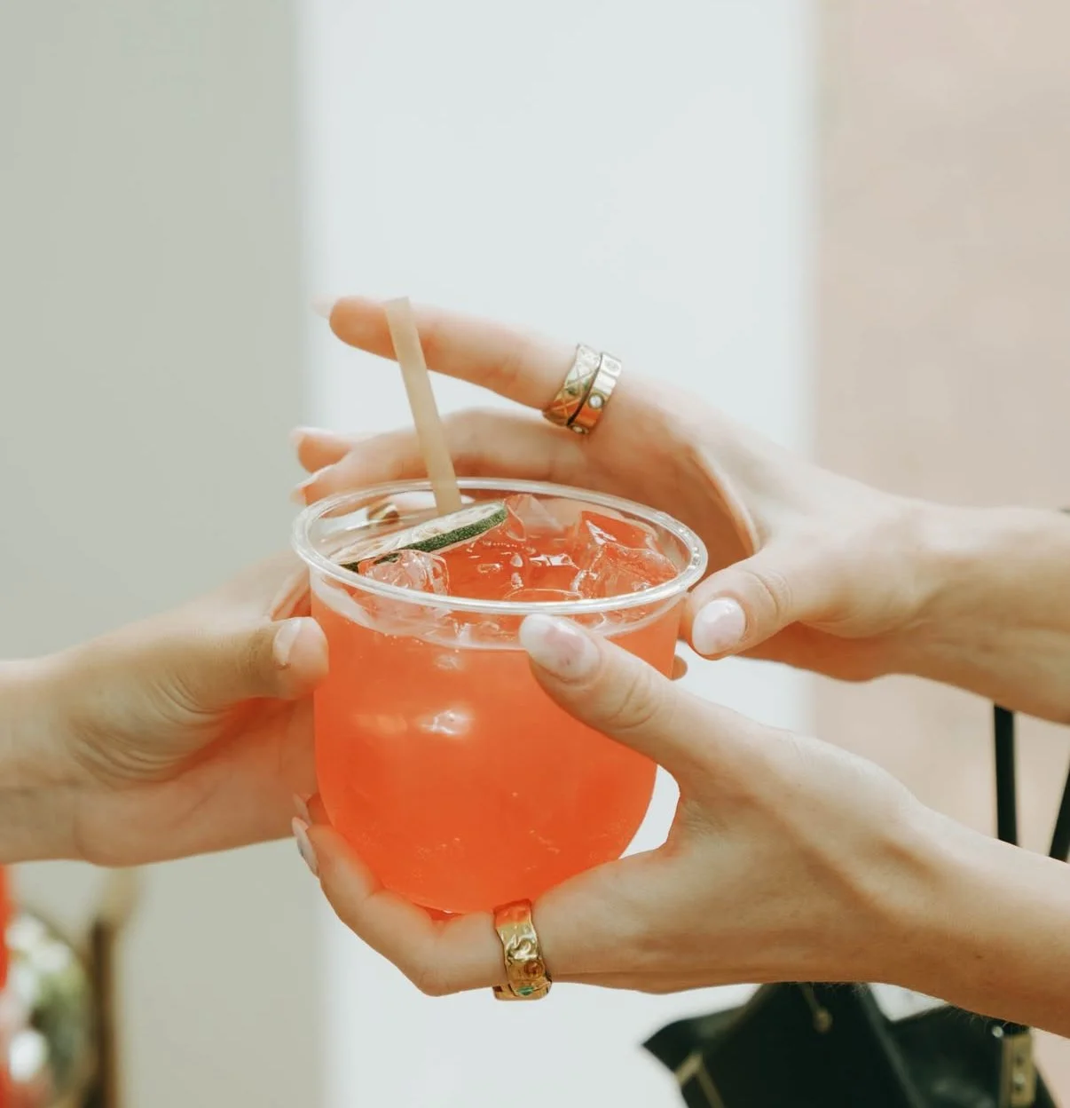 Guests exchanging a craft cocktail garnished with citrus at a Tap Social mobile bar event in South Florida