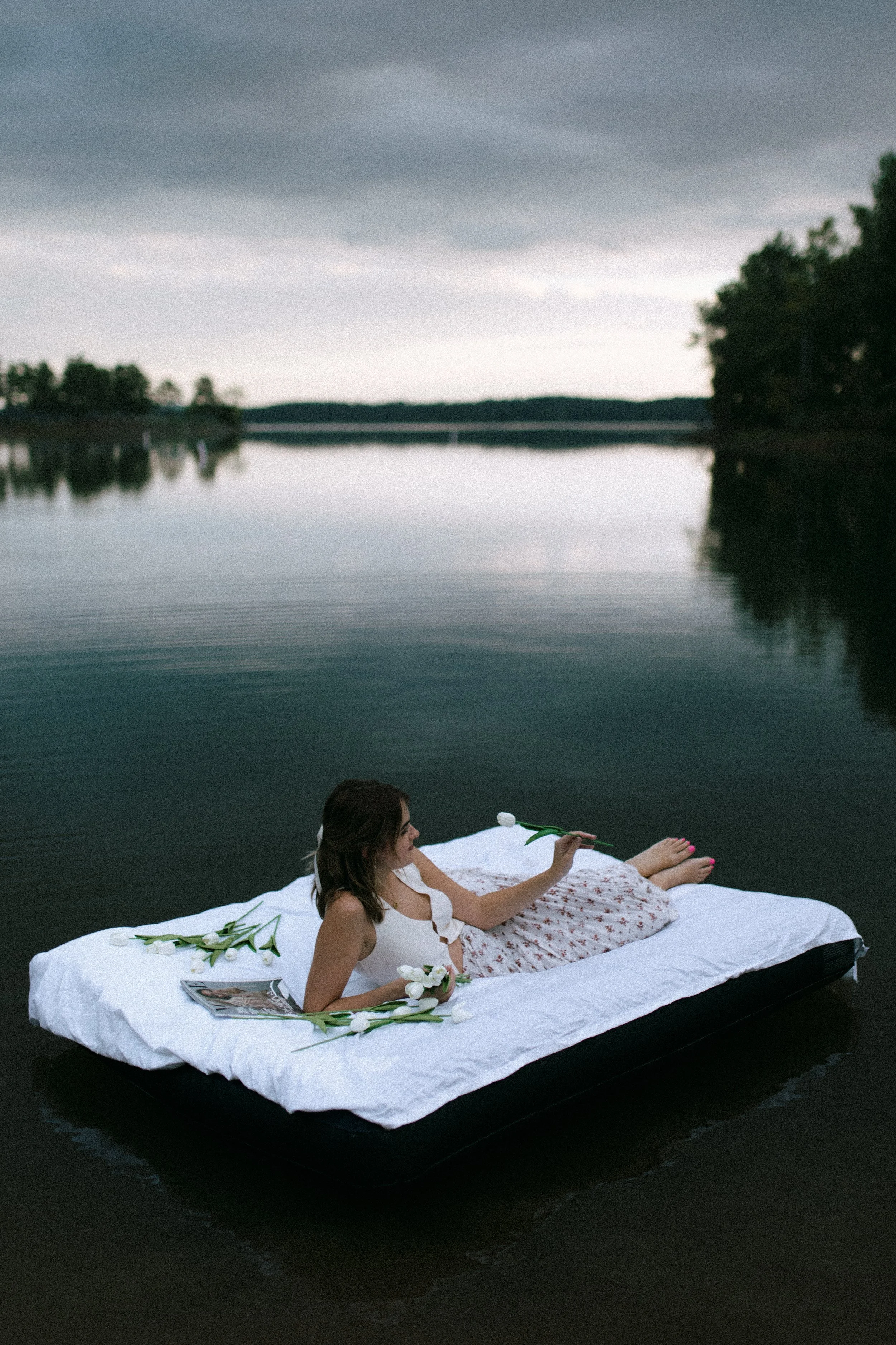 Woman relaxing on air mattress with flowers on a lake