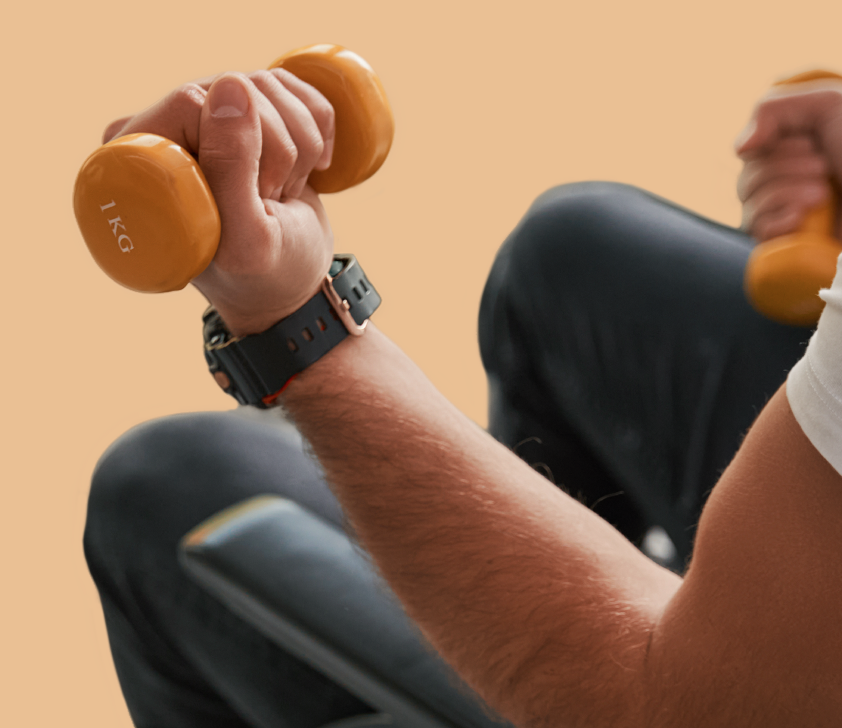 Person lifting a 1 kg orange dumbbell.