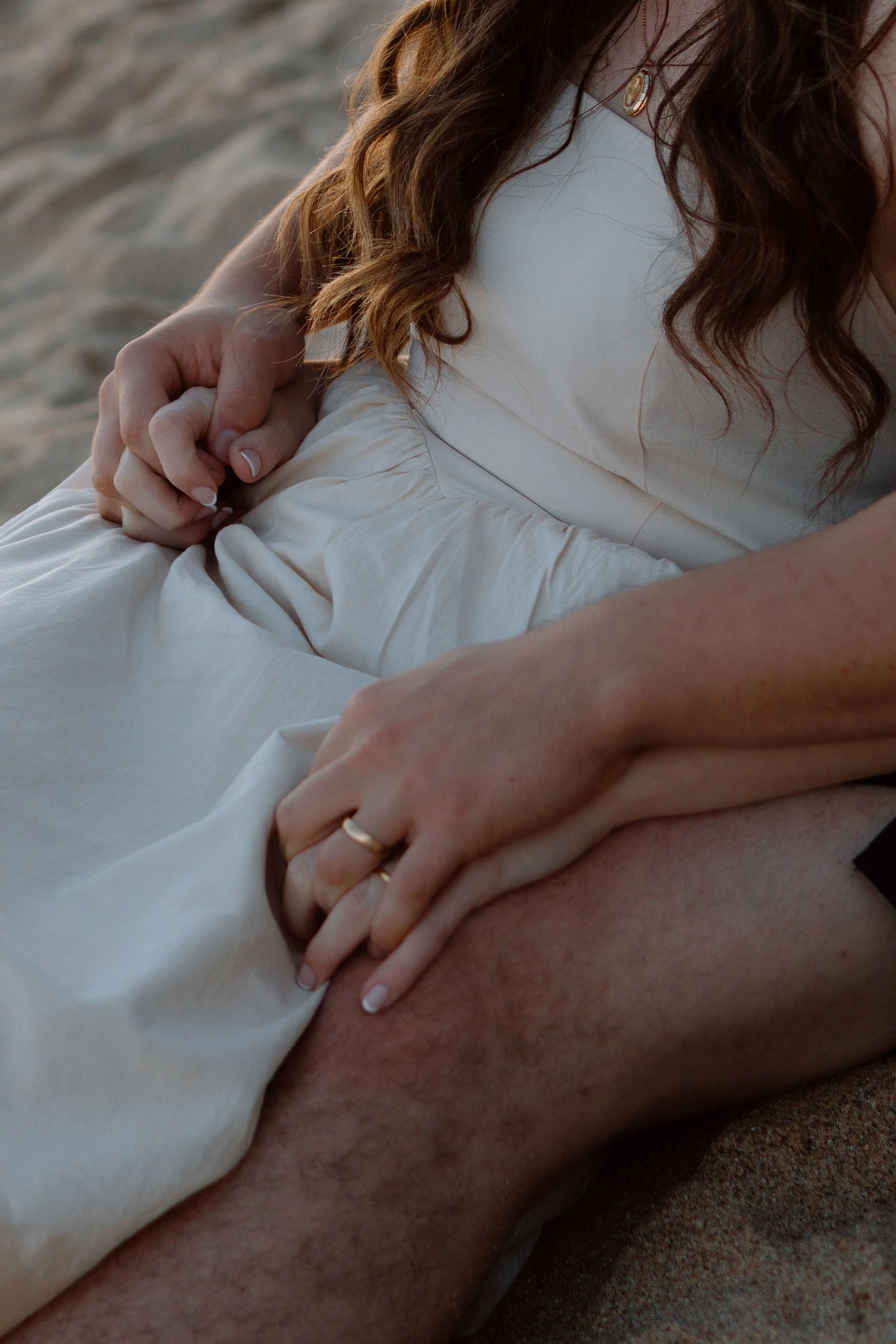 Close-up of a bride’s hands and wedding ring on the beach during a Lisbon couples photography session
