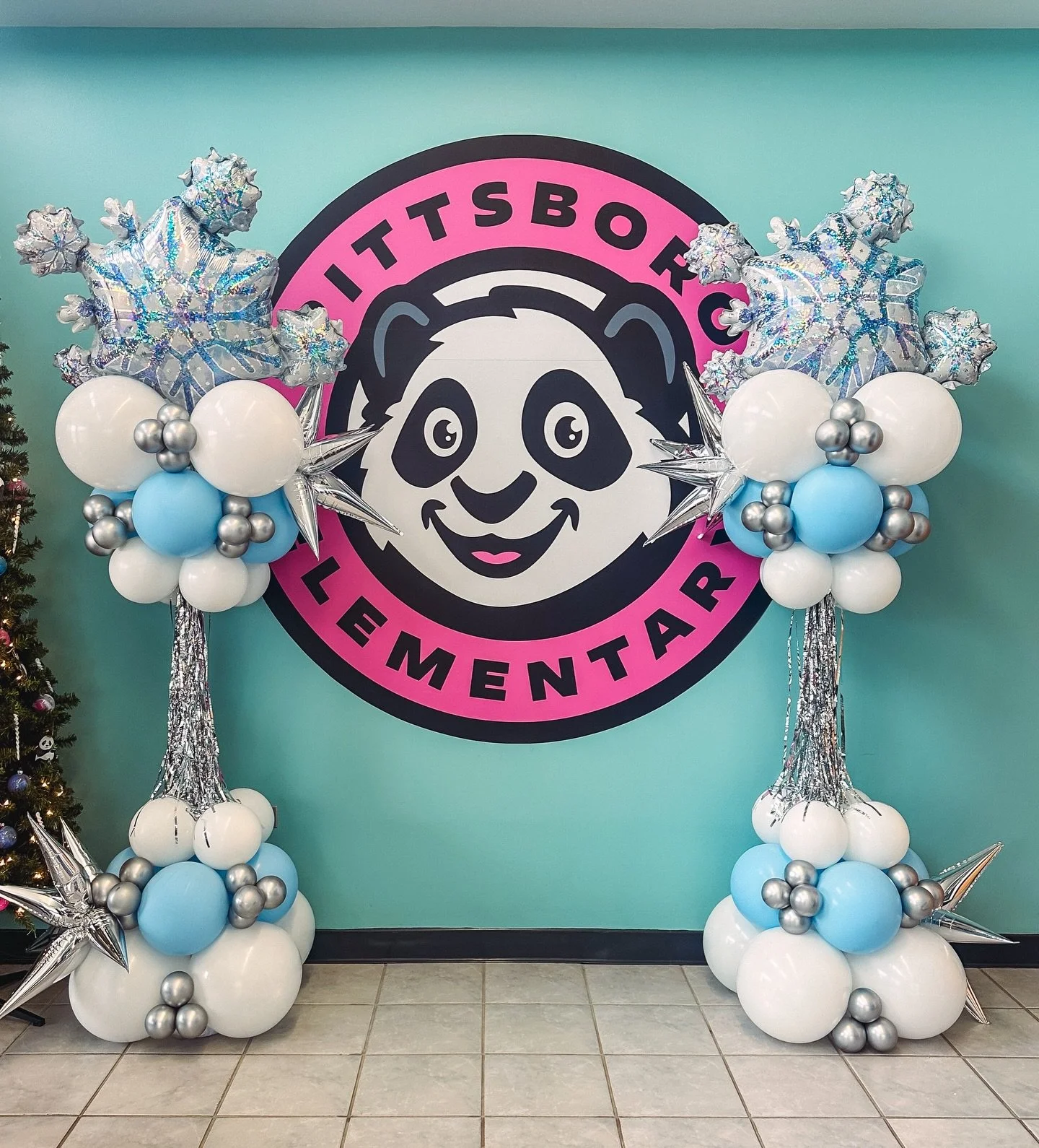 Balloon arrangements with silver, white, and blue balloons, including snowflake-shaped balloons