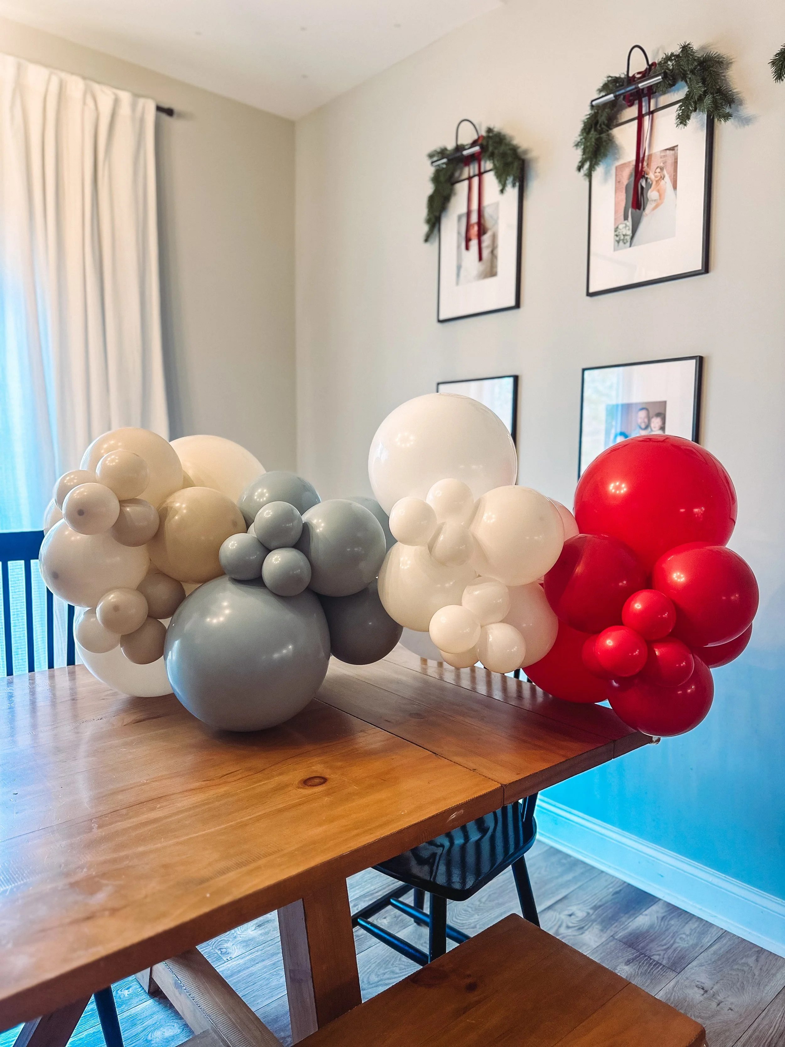Balloon arrangement with white, blue, and red balloons 