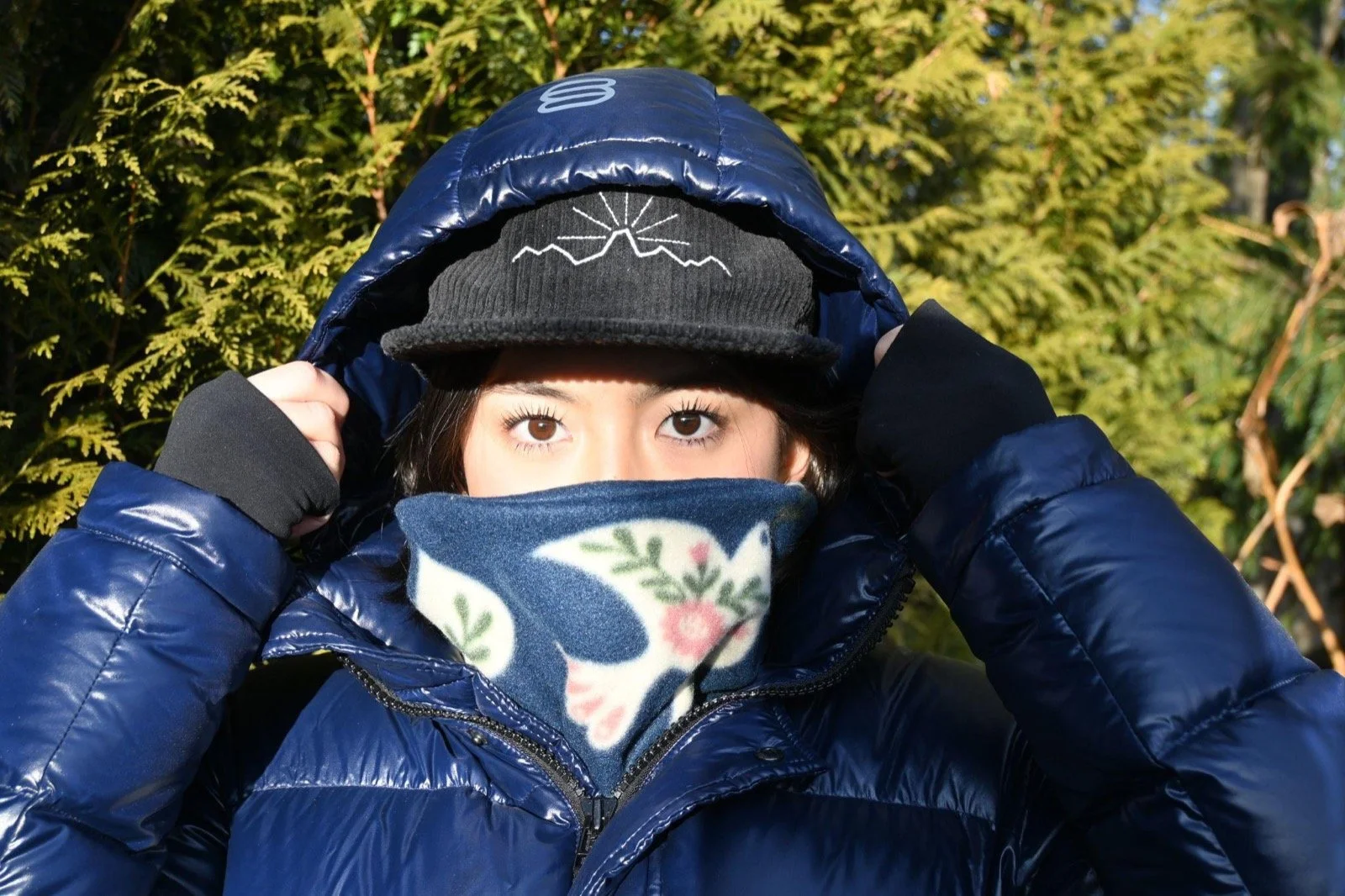 Rider in a dark hooded jacket wearing the Freebird fleece neckie up to their nose