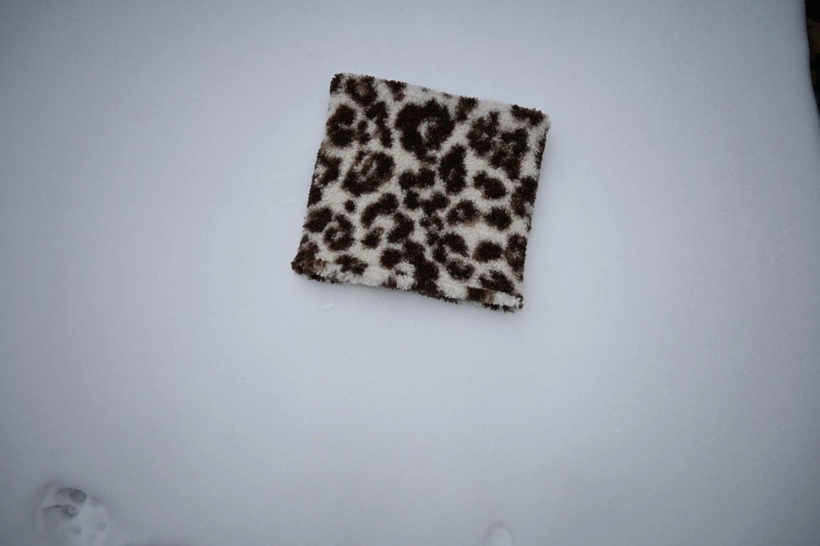 Leopard Sherpa Neckie laid flat on a light gray background