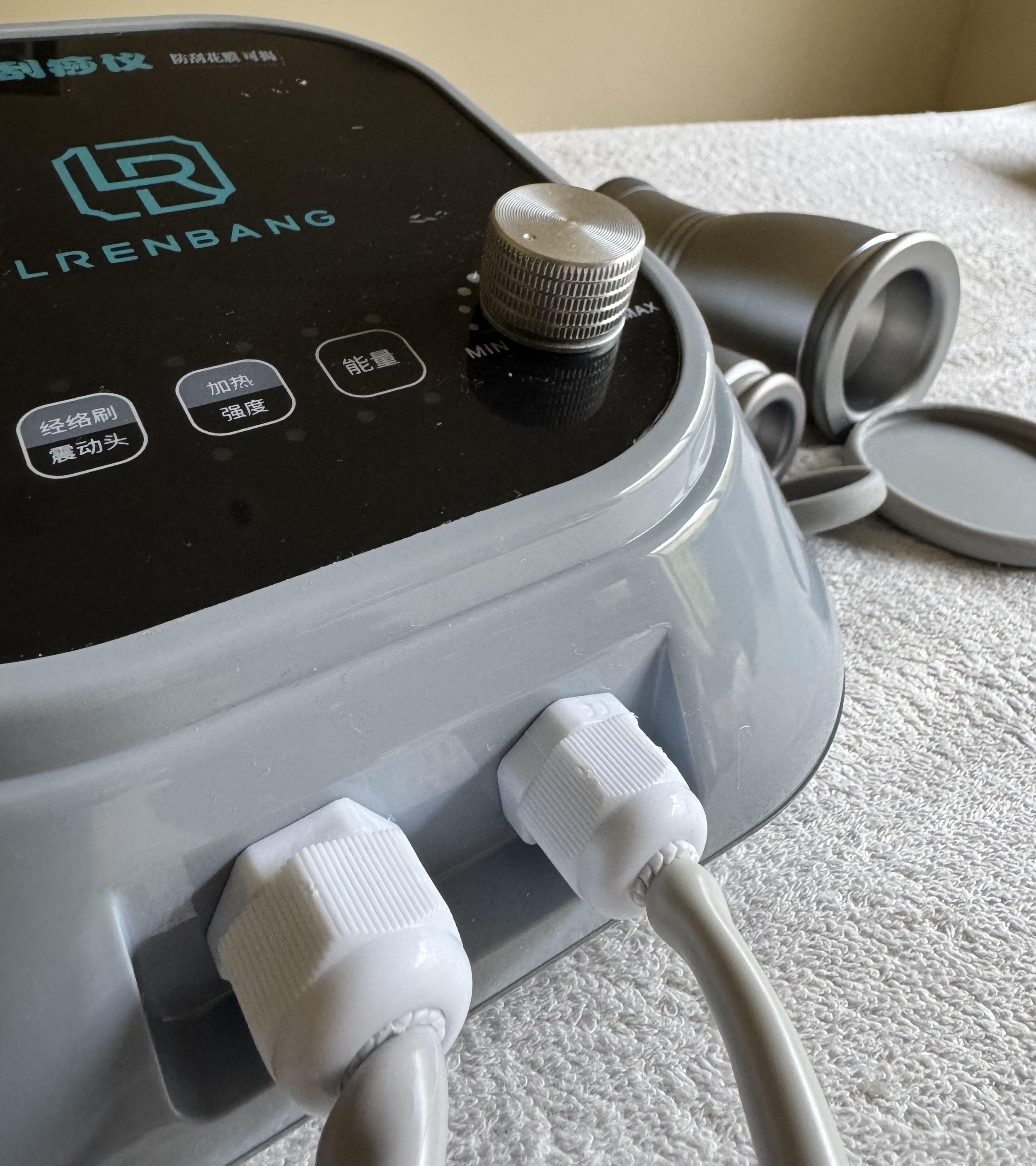 Close-up of a medical device with control knobs, digital display, and binoculars in the background, representing modern diagnostic support at The Gentle Needle Guy’s acupuncture clinic in Brisbane.