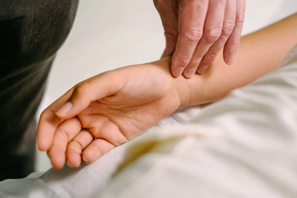 Person checking the pulse on a wrist, demonstrating Traditional Chinese Medicine pulse diagnosis techniques used to guide acupuncture treatment at The Gentle Needle Guy’s clinic in Brisbane.