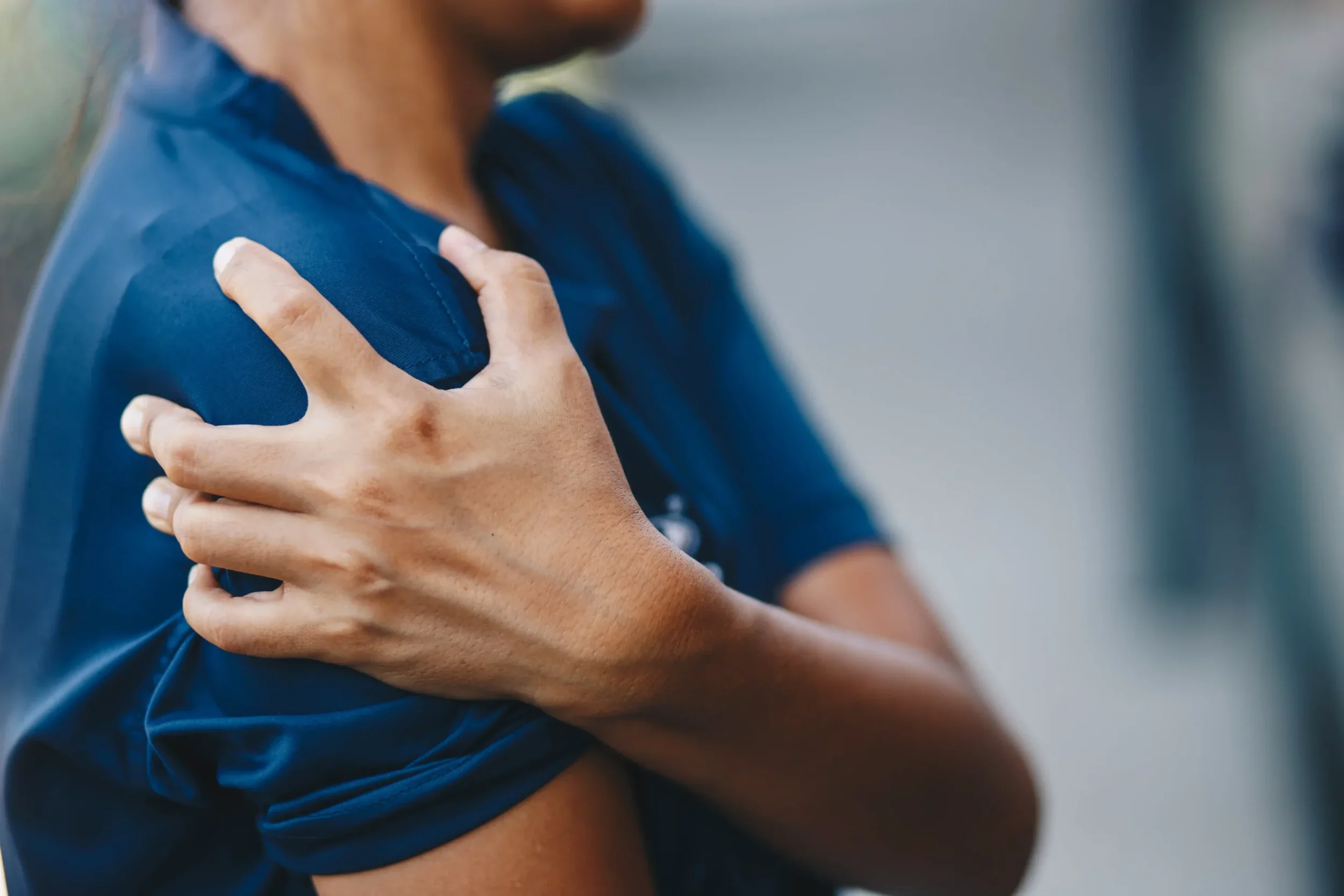 Person holding shoulder demonstrating upper shoulder pain relief support with acupuncture in Brisbane