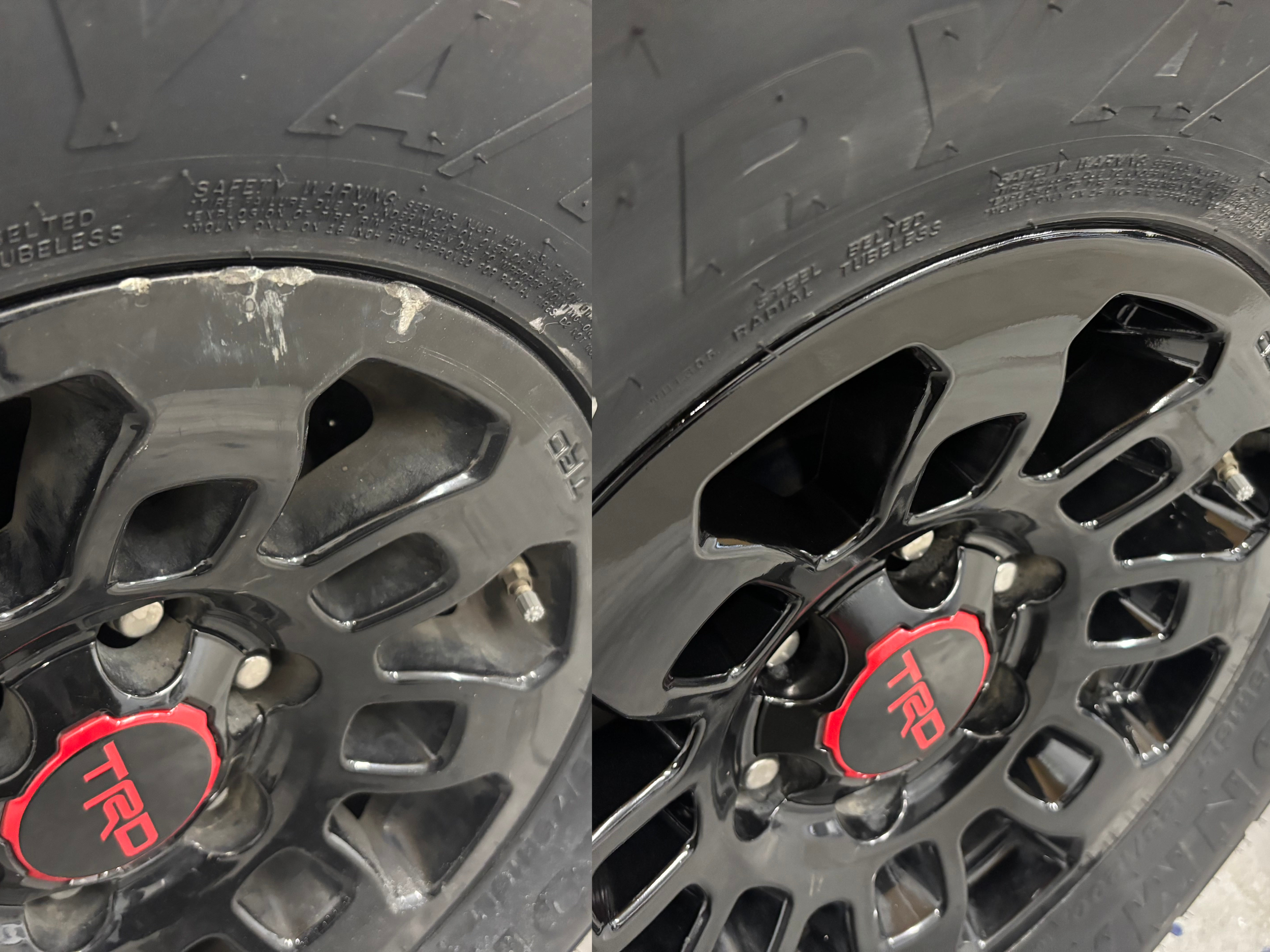 Close-up of a black alloy wheel with a red TRD center cap on a tire, showing the wheel's spokes and tire sidewall.