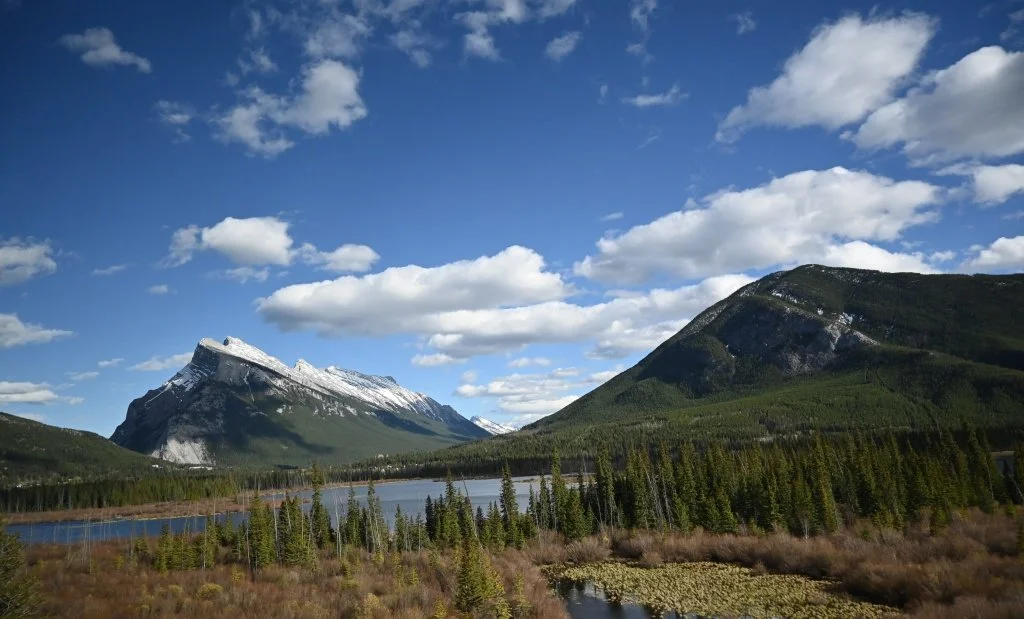 Snow-capped mountains and a lake seen from a bus window along the Icefields Parkway near Banff, Alberta.