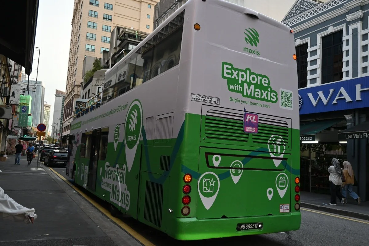 Explore with Maxis branded green double-decker bus