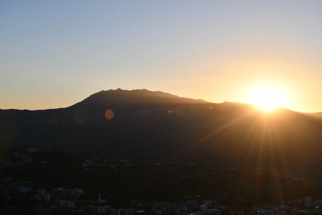 Sunset sunstar glow over the hills above Chefchaouen, Morocco
