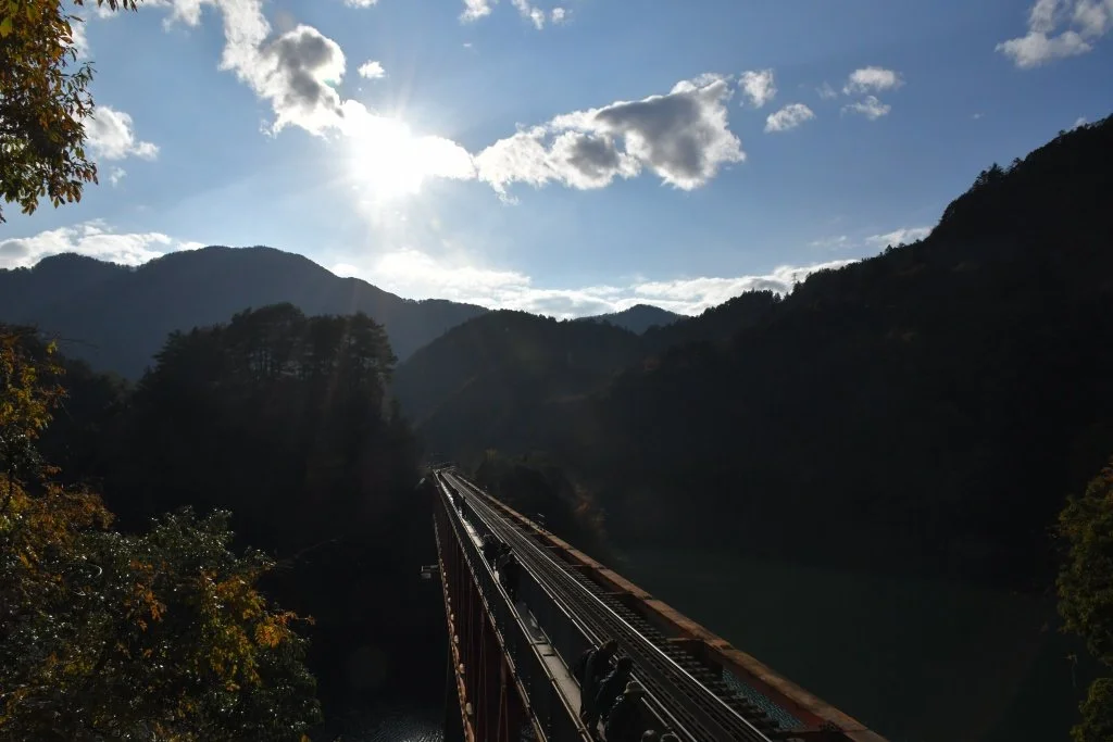 Sunstar over a railway bridge and mountain valley, Okuoikojo Station Observatory, Japan