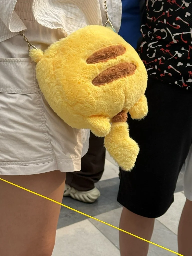 A Pikachu-shaped plush crossbody bag worn as an accessory at PokéXciting! Kuala Lumpur.