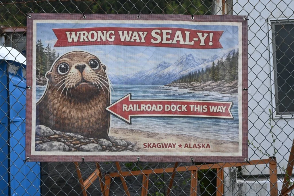 Humorous seal directional sign pointing to Railroad Dock in Skagway Alaska reading Wrong Way Seal-y