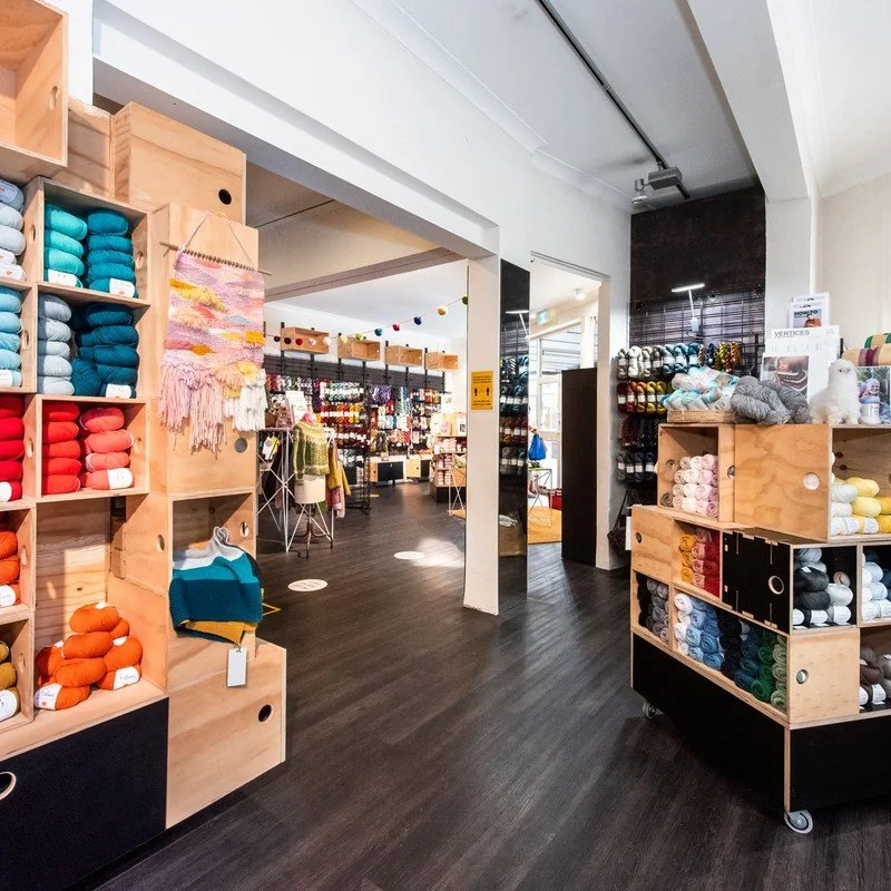 Timber shelving stocked with colourful yarn in a small retail fitout, Skein Sisters
