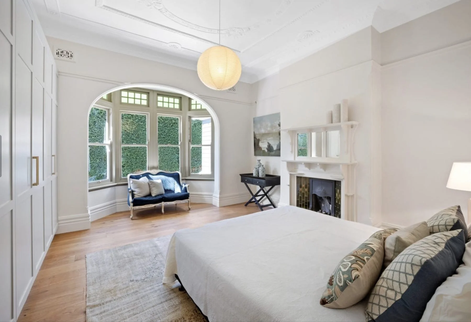 Period bedroom with arched windows and an original fireplace in a Federation home