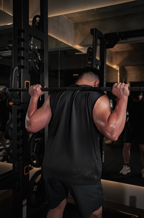 Man lifting a barbell during a workout at the gym.
