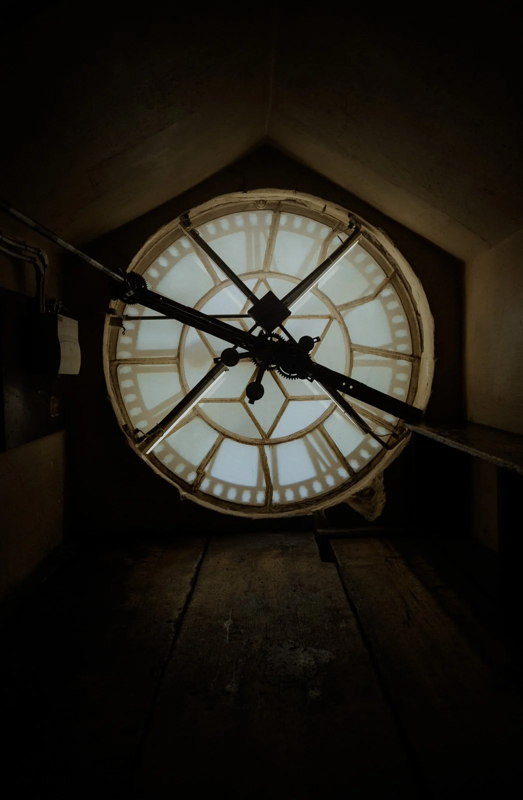 Backlit clock face and mechanism viewed from inside the tower of Bath Abbey — architectural photography by Wild Mind Studios