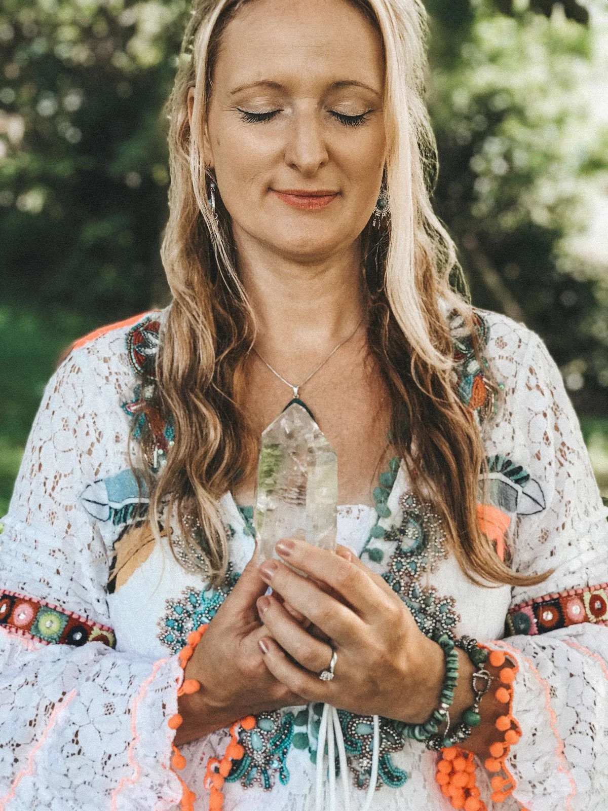 Woman in bohemian dress holding a crystal with eyes closed, outdoor personal branding photography for Emma Penman by Wild Mind Studios