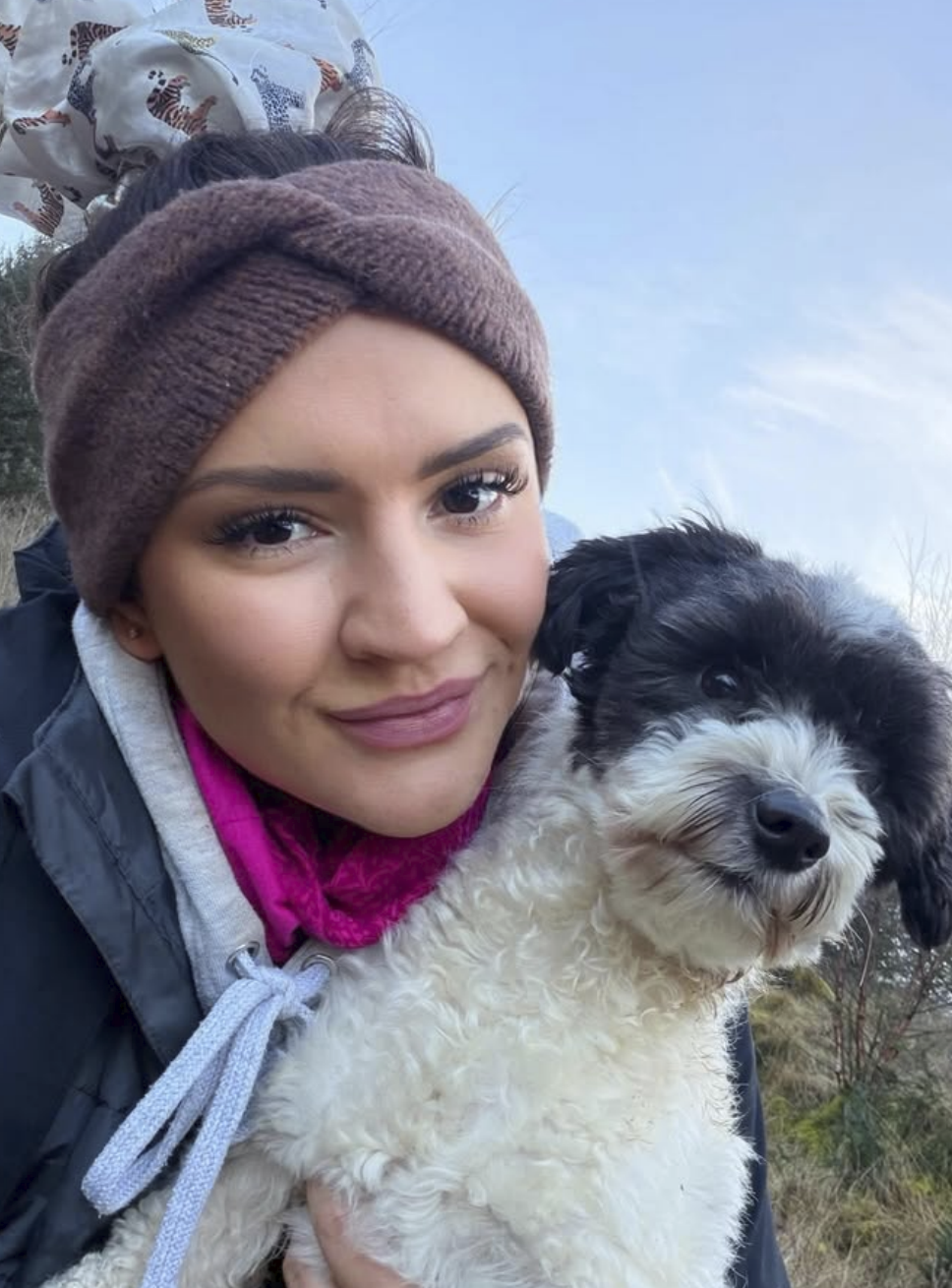 Portrait of Ellen, founder of Woof Terrain, holding a dog outdoors. A client of Wild Mind Studios for professional dog-walking branding and Squarespace web design.