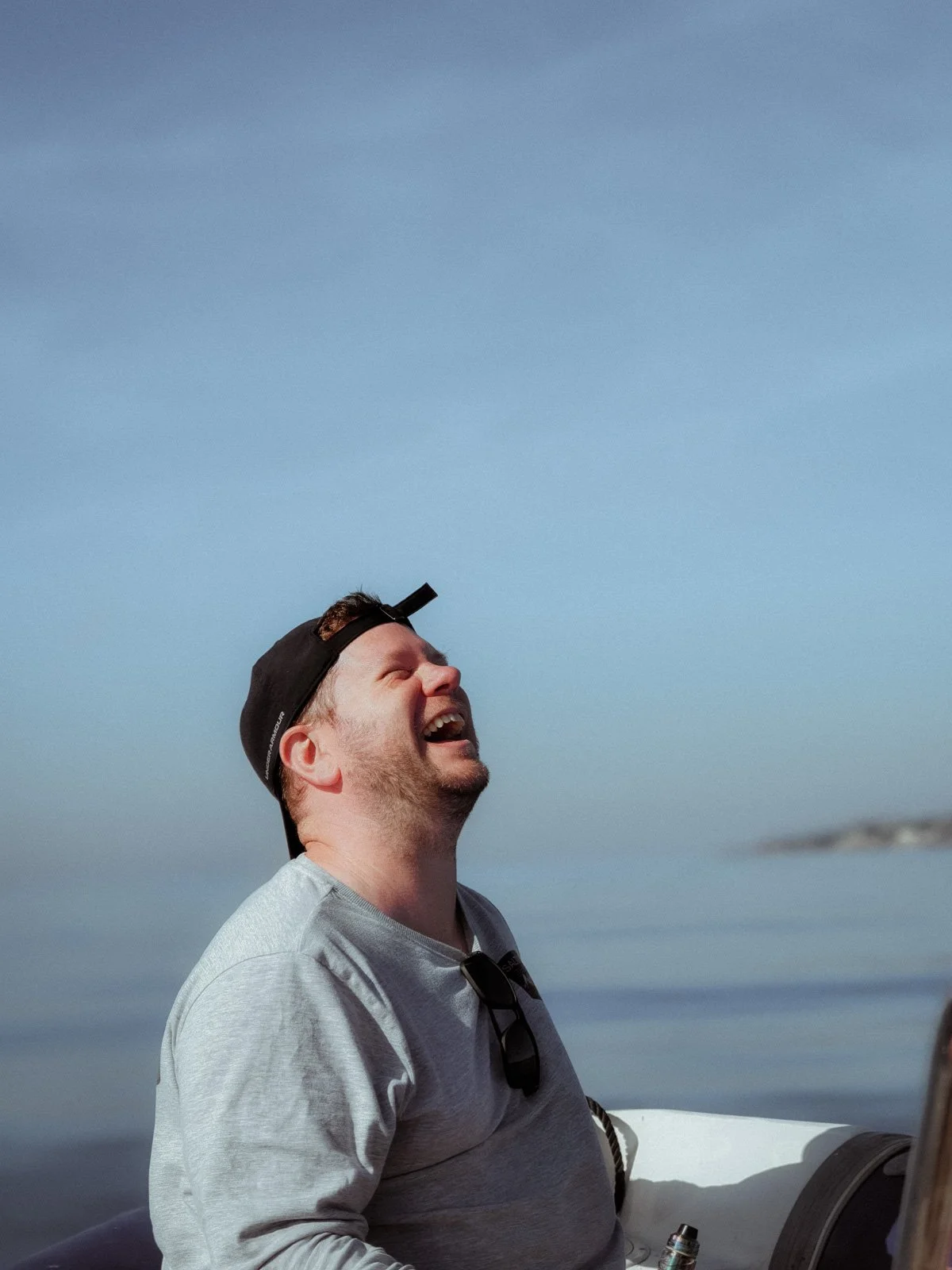 Matt laughing on a boat with the sea in the background — Wild Mind Studios About page